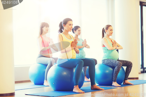 Image of happy pregnant women exercising on fitball in gym