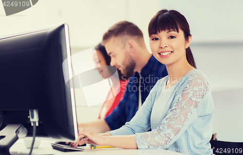 Image of happy creative team or students working at office