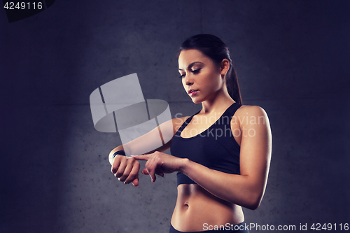 Image of young woman with heart-rate watch in gym