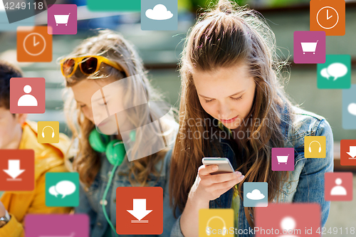 Image of happy teenage friends with smartphones outdoors