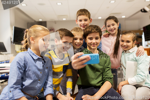 Image of group of school kids taking selfie with smartphone