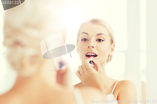 Image of woman with lipstick applying make up at bathroom