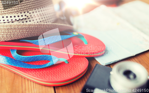 Image of close up of travel map, flip-flops, hat and camera