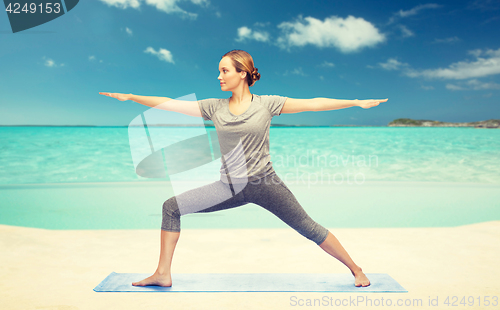 Image of woman making yoga warrior pose on mat