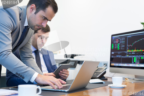 Image of Business team remotely solving a problem at business meeting using laptop computer and touchpad.