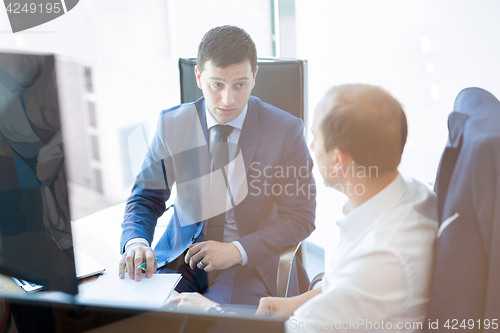 Image of Two businessmen discussing a bisiness problem at meeting in trading office.