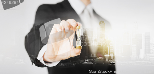 Image of close up of businessman hand holding hourglass