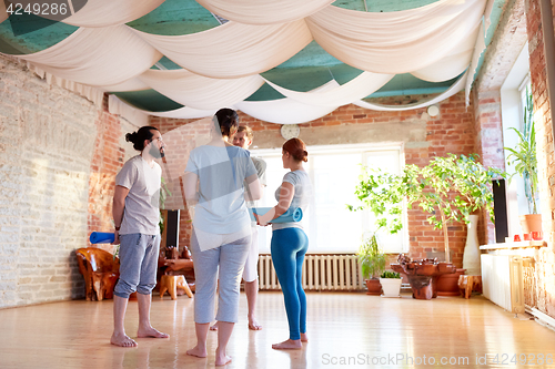 Image of group of people with mats at yoga studio or gym