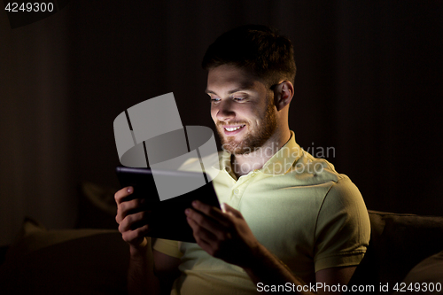 Image of young man with tablet pc computer at night 
