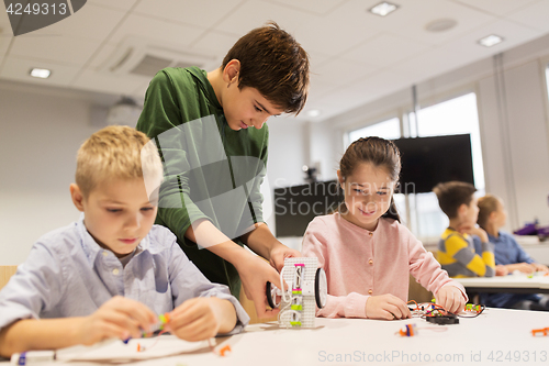 Image of happy children building robots at robotics school