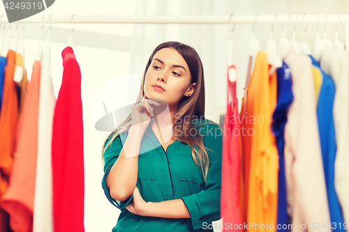 Image of woman choosing clothes at home wardrobe