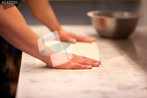 Image of chef hands preparing dough on table at kitchen