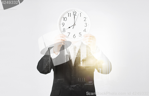 Image of businessman with wall clock