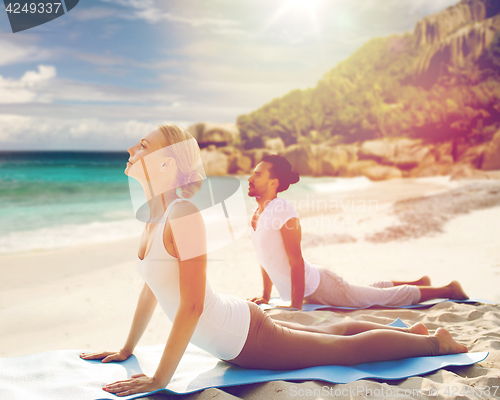 Image of couple making yoga upward facing dog pose outdoors