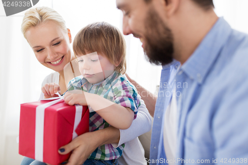 Image of happy family with birthday gift at home