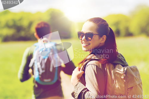 Image of happy couple with backpacks hiking outdoors