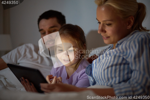 Image of happy family with tablet pc in bed at home