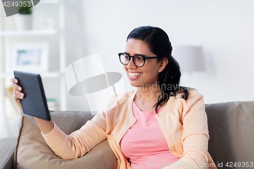 Image of happy indian woman with tablet pc at home