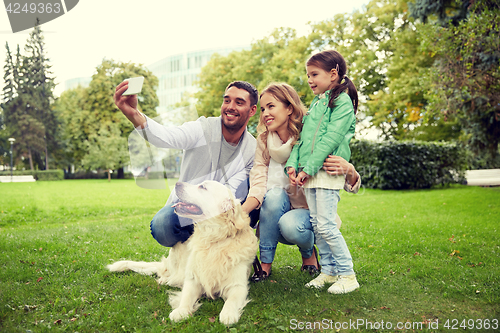 Image of happy family with dog taking selfie by smartphone