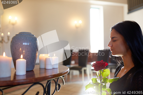 Image of woman with rose and funerary urn at church