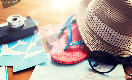 Image of close up of travel map, flip-flops, hat and camera