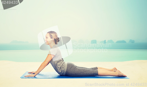 Image of woman making yoga in dog pose on mat