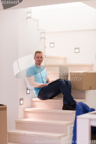 Image of young man sitting in stairway at home