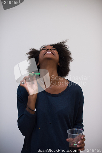 Image of black woman in party hat blowing in whistle