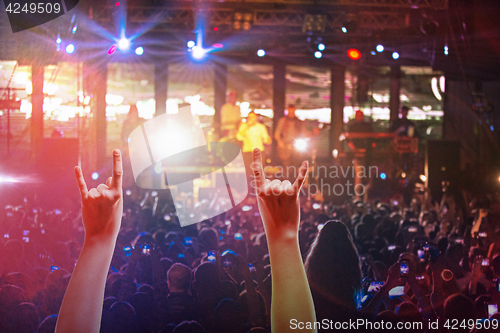 Image of The silhouettes of concert crowd in front of bright stage lights