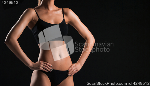 Image of Muscular young woman athlete on black