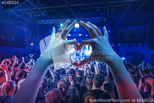 Image of The silhouettes of concert crowd in front of bright stage lights