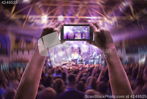 Image of The silhouettes of concert crowd in front of bright stage lights