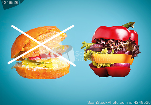Image of The healthy sandwich with fresh pepper, onion, salad lettuce and unhealthy harmful hamburger