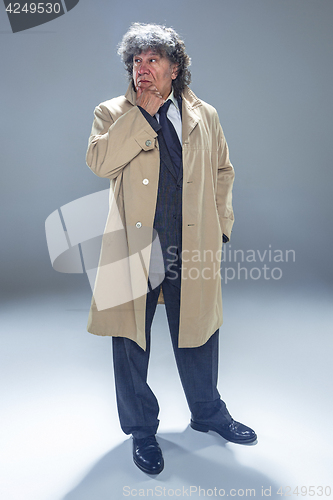 Image of The senior man as detective or boss of mafia on gray studio background