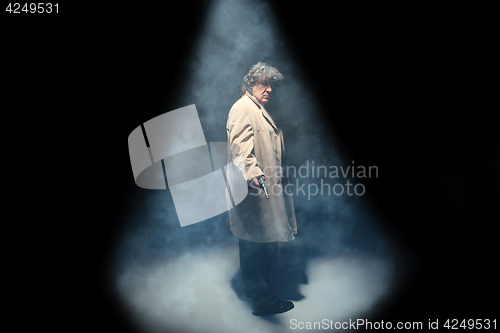 Image of Senior police agent with a gun on dark smoke background