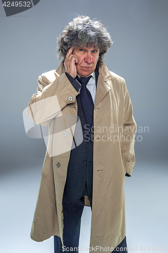 Image of The senior man as detective or boss of mafia on gray studio background