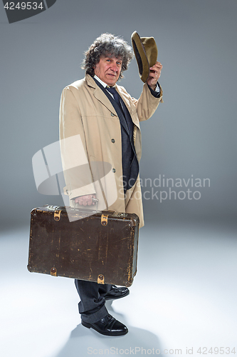 Image of The senior man as detective or boss of mafia on gray studio background