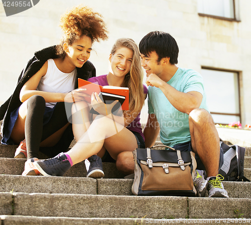 Image of cute group of teenages at the building of university with books huggings, back to school