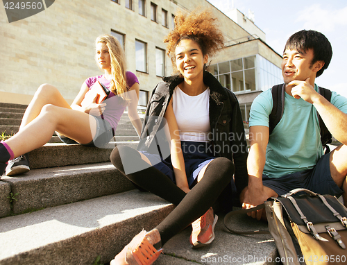 Image of cute group teenages at the building of university with books huggings