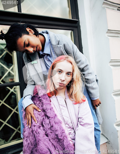Image of Two teenage girls infront of university building smiling, having