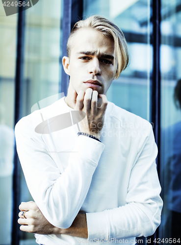 Image of young modern hipster guy at new building university blond fashio