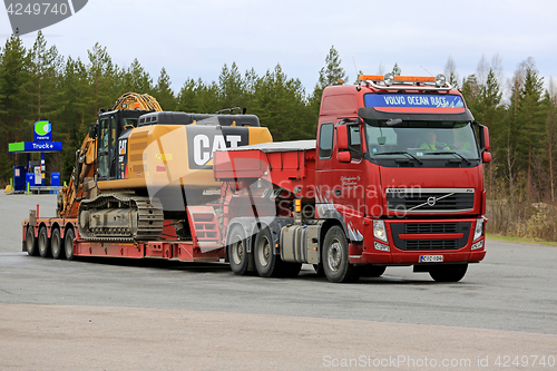 Image of Volvo FH Semi Hauls Cat Excavator on Flat Trailer 