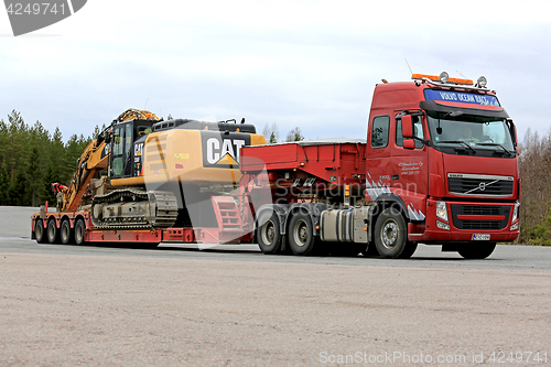 Image of Red Volvo FH Hauls Large Excavator on Trailer