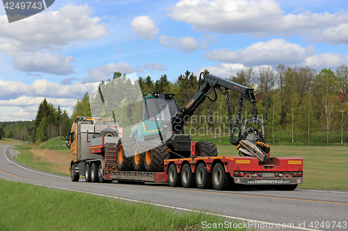 Image of Semi Truck Transports Forestry Harvester at Spring