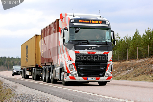 Image of Volvo FH with Red Stripes Hauls Containers along Road