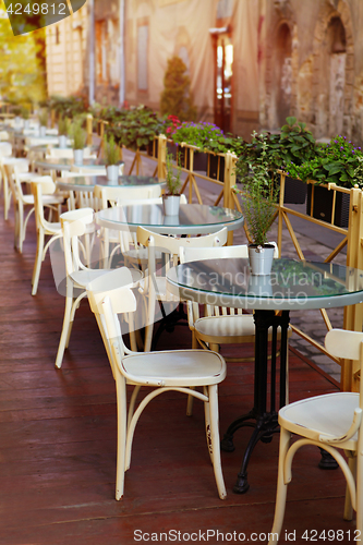 Image of empty little white tables of cafeteria