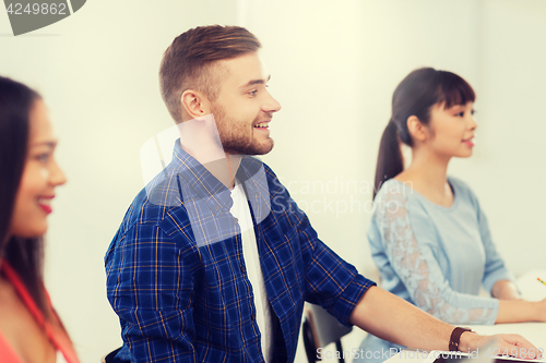 Image of happy creative team or students working at office