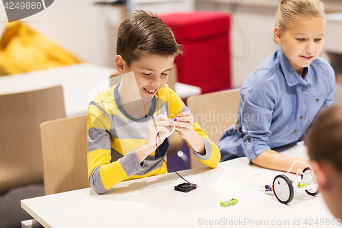 Image of happy children building robots at robotics school