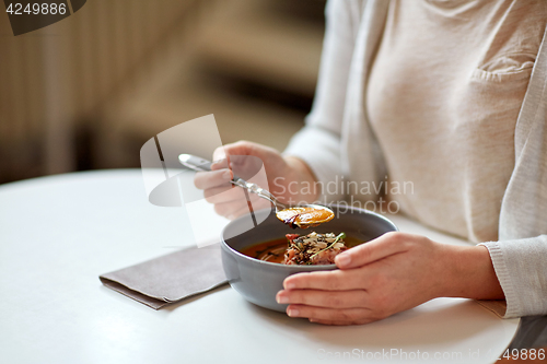 Image of woman eating pumpkin cream soup at restaurant