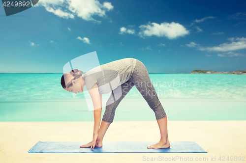 Image of woman making yoga intense stretch pose on mat